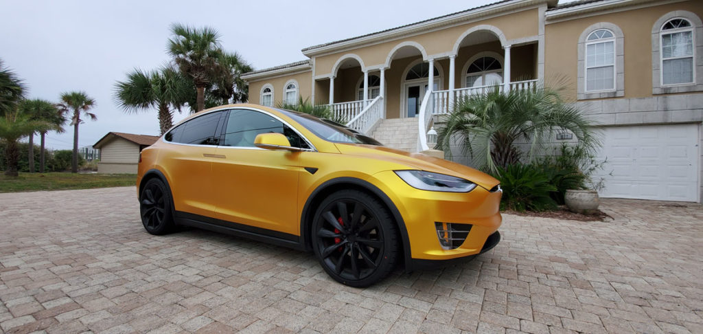 Vinyl-wrapped car parked under shade to avoid sun damage.